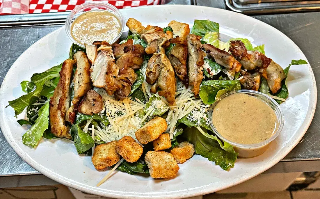 Grilled chicken caesar salad with shaved parmesan and croutons, food photography by chef J.O. King