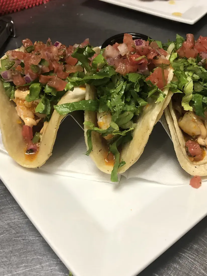 Three chicken street tacos topped with pico de gallo and shredded lettuce, food photography by chef J.O. King