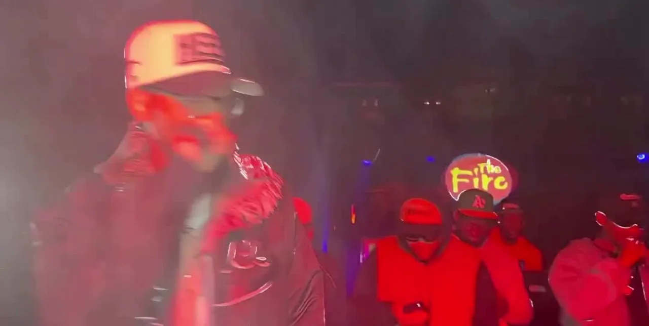 Performer on stage in red light and haze at The Fire — live concert coverage by 066 Media